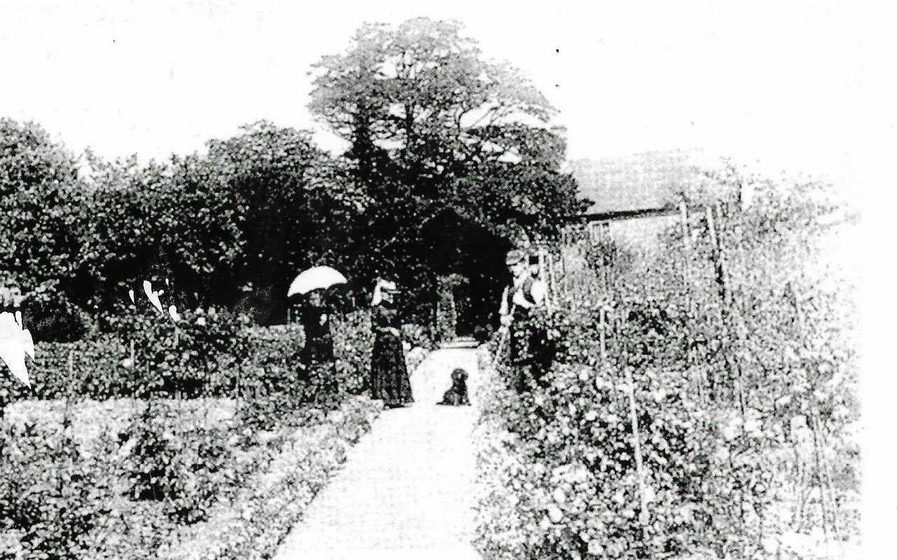 Three people and a dog in the gardens of Shifnal Cottage hospital